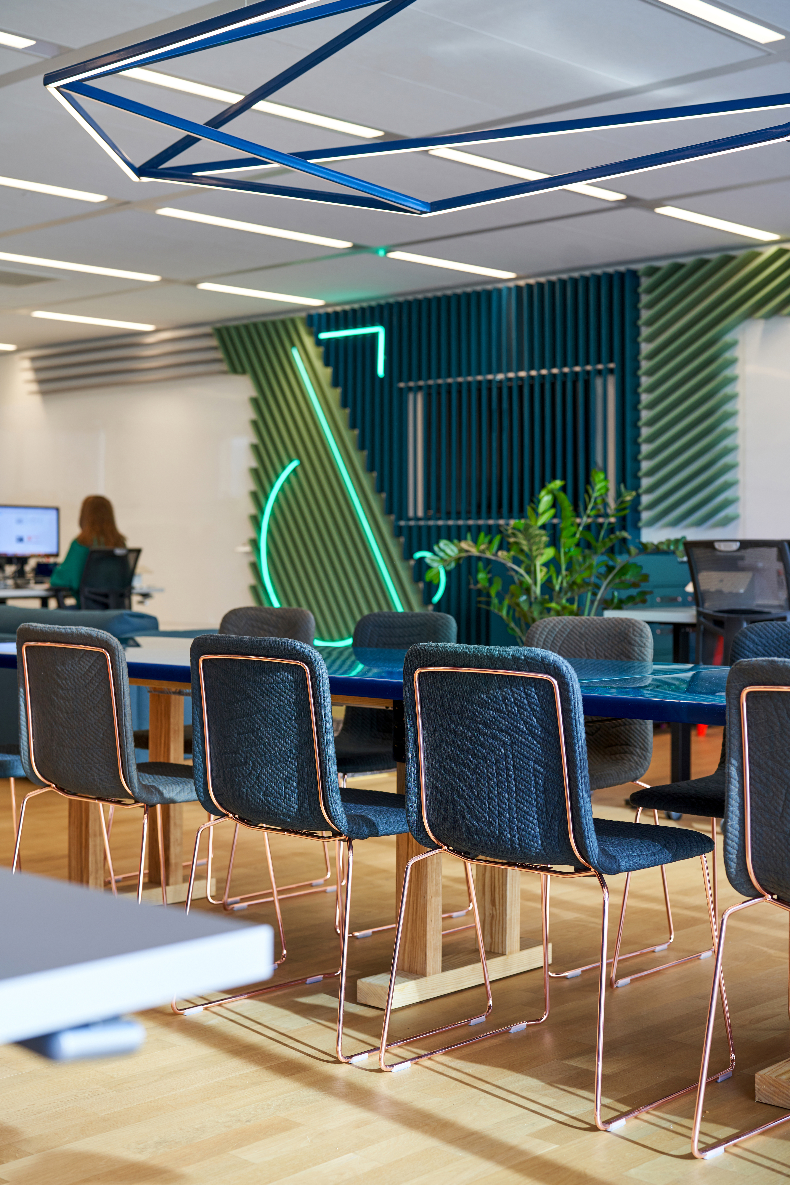 Op de werkvloer is de op maat gemaakte stamtafel met daarboven een speciaal ontworpen lichtelement het middelpunt. Epoxy als tafelblad in het karakteristieke groen reflecteert op bijzonder wijze het licht van het element boven de tafel. fotografie Philip Jintes @ Phenster
