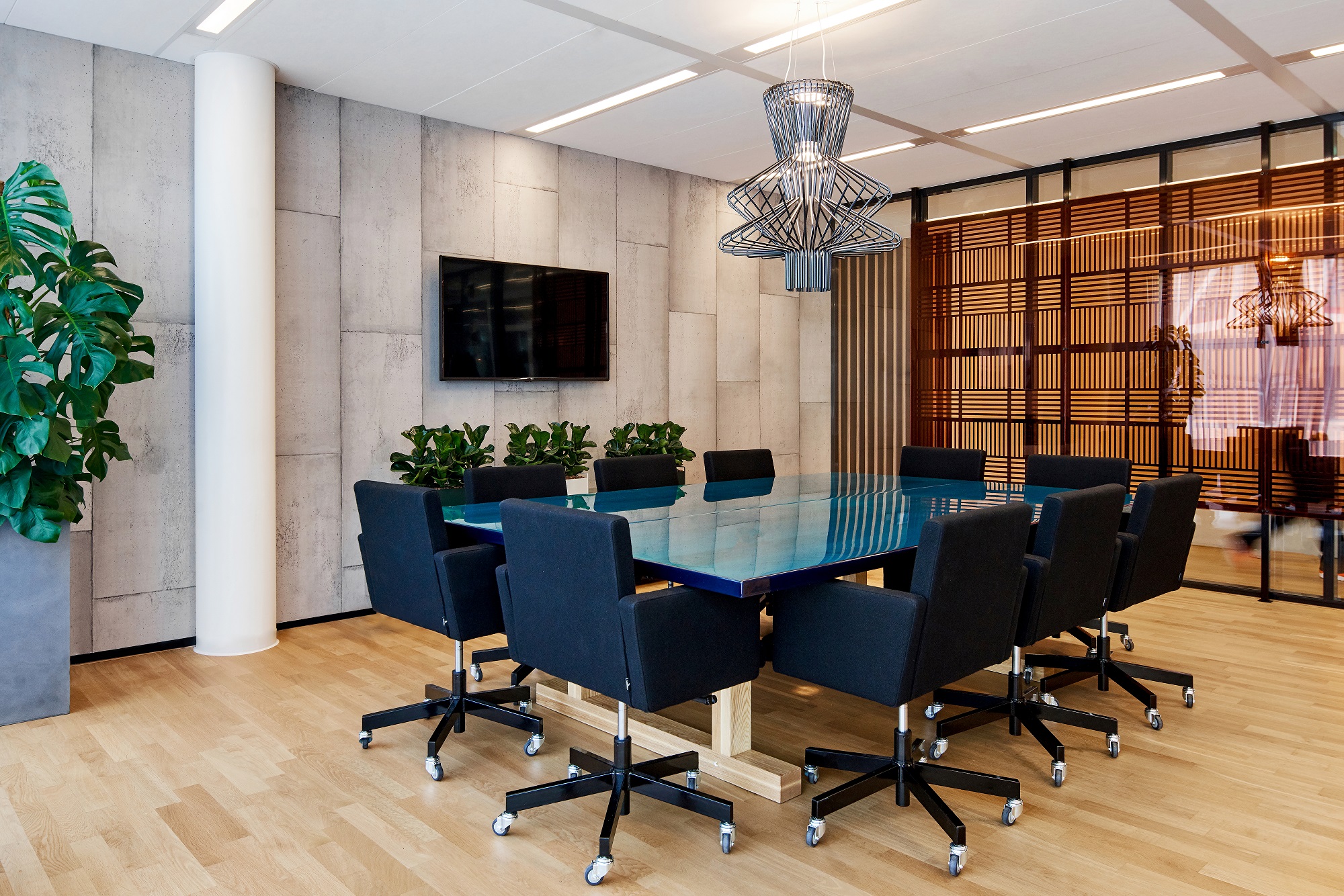 In de stoere en open vergaderruimte is de tafel, massief hout, dik afgegoten met op kleur gemaakte, transparante epoxy, de eyecatcher. De strakke stoelen van Atelier van Lieshout voor Lensvelt en het behang van Piet Boon voor NLXL maken het stoere beeld af. fotografie Philip Jintes @ Phenster