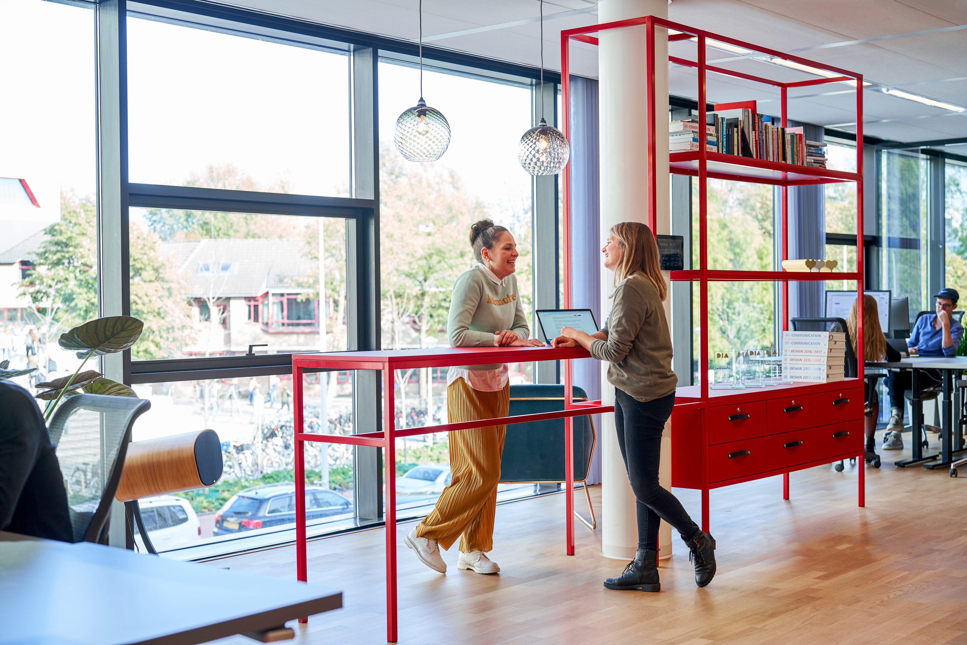 Als accent zijn op verschillende plekken in de ruimtes rode elementen toegevoegd, zoals deze overlegplek die tevens prijzenkast is. fotografie Philip Jintes @ Phenster