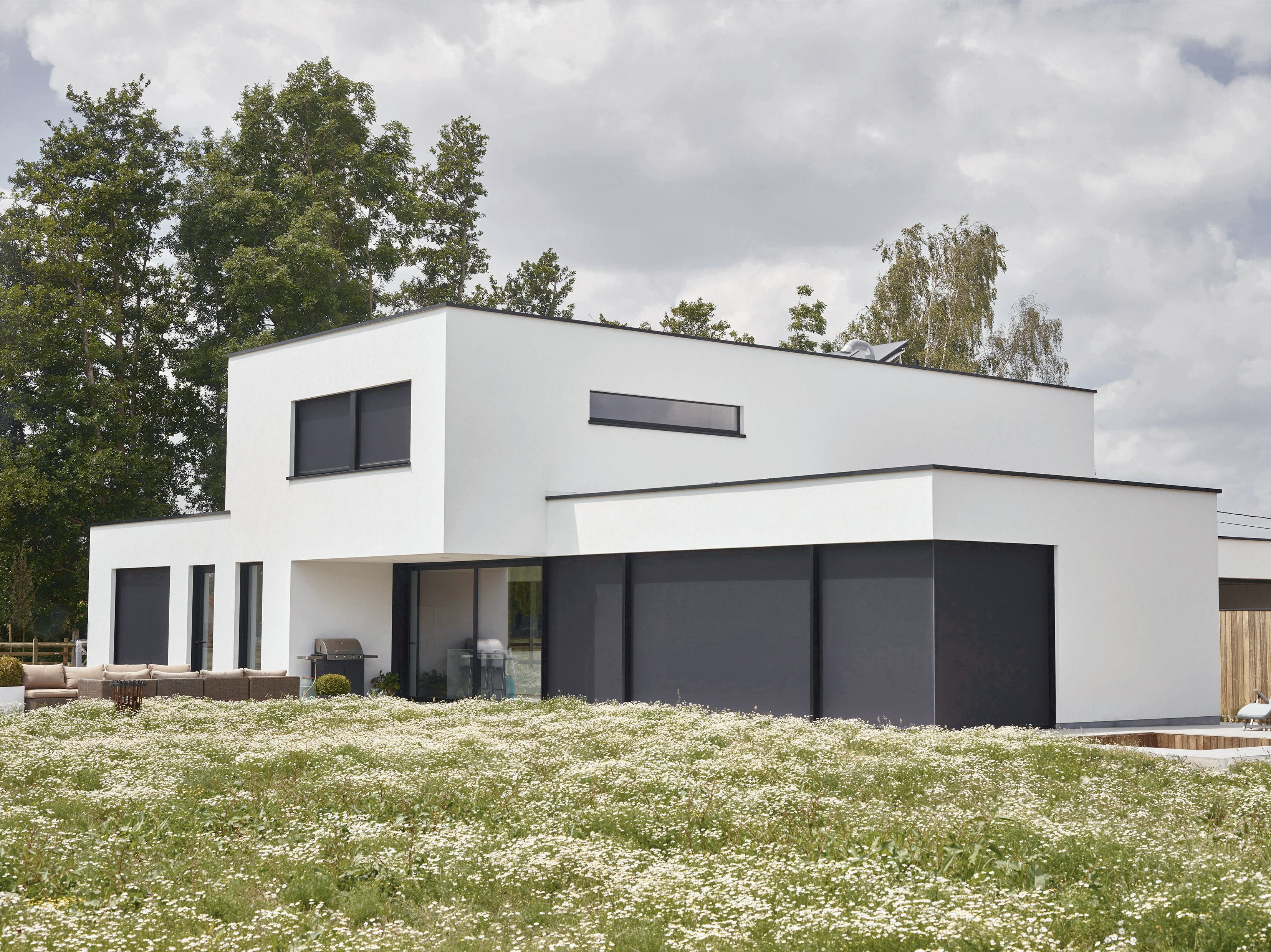 De grote raampartijen van de strakke villa zijn gericht op het zuiden en zorgen voor veel daglicht in de keuken en leefruimte. Door het overvloedige zonlicht was een zonwering noodzakelijk.