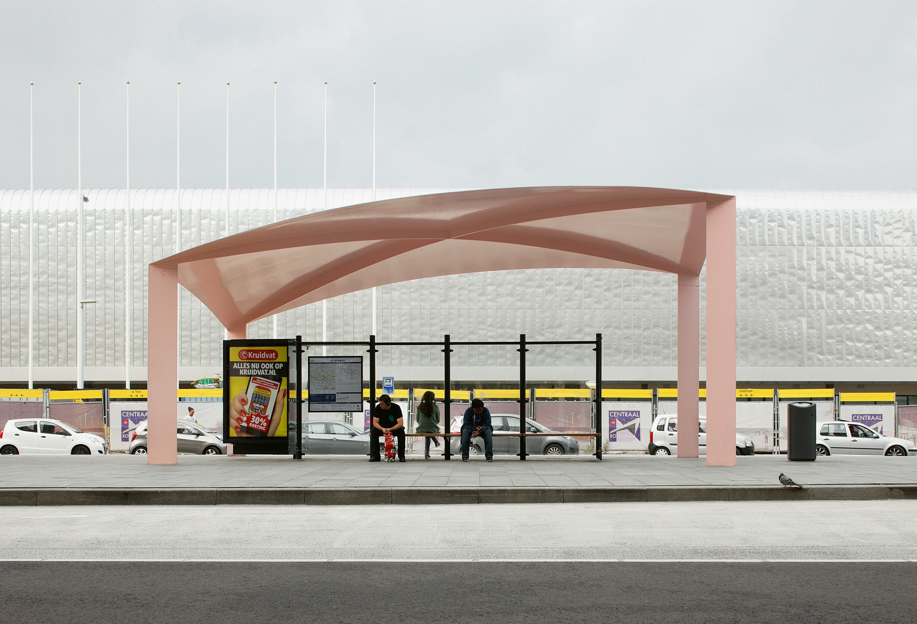 Het nieuwe busstation van Rotterdam bestaat uit drie lichte constructies voor wachtende passagiers. Ze bestaan uit een dunne staalplaat van vijf bij tien meter die ofwel opbolt ofwel inzakt, en vier platte stalen, diagonaal opgestelde kolommen die het dakvlak ondersteunen - Beeld Filip Dujardin