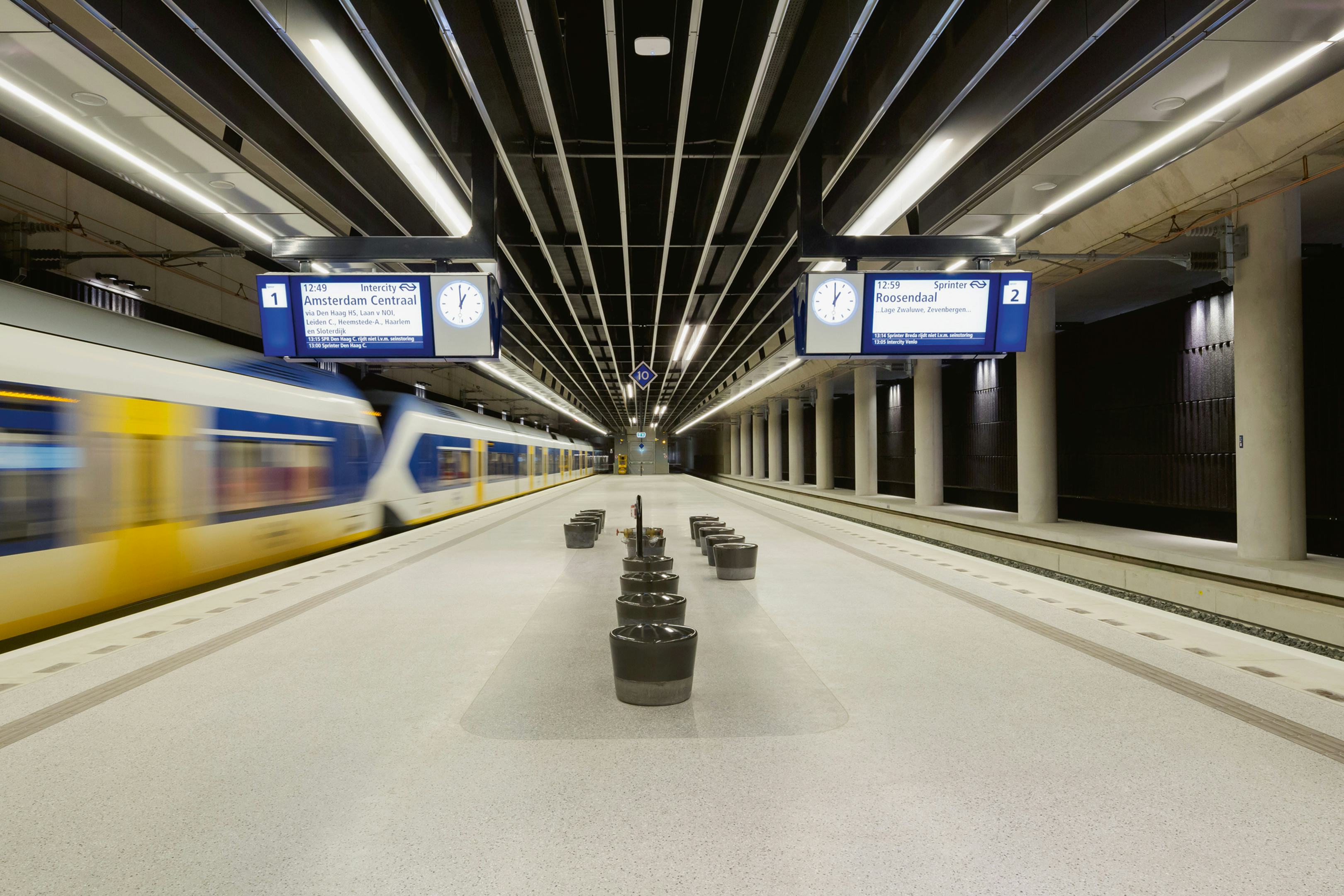 De perrons bieden een rustig beeld. Palen, seinen, borden en dergelijke zijn zo veel mogelijk geïntegreerd in het perronontwerp. Techniek is voor het grootste deel weggewerkt achter of onder het verlaagde plafond. Voorbijrijdende treinen maken nauwelijks lawaai. Foto Jannes Linders