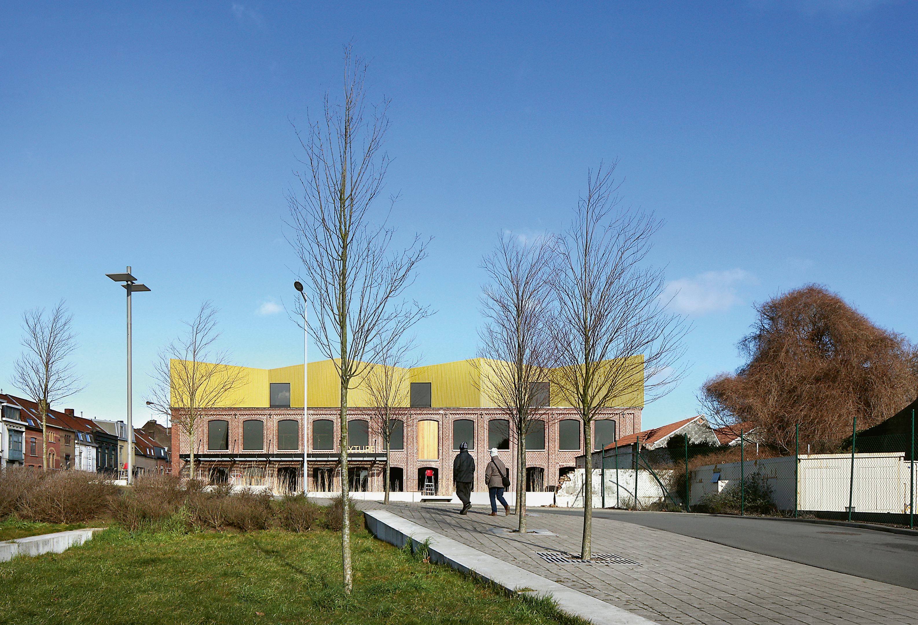 Het Texture Museum van Kortrijk door noA architecten is door middel van een hellend voorplein verbonden met de rivier de Leie - Beeld Filip Dujardin

