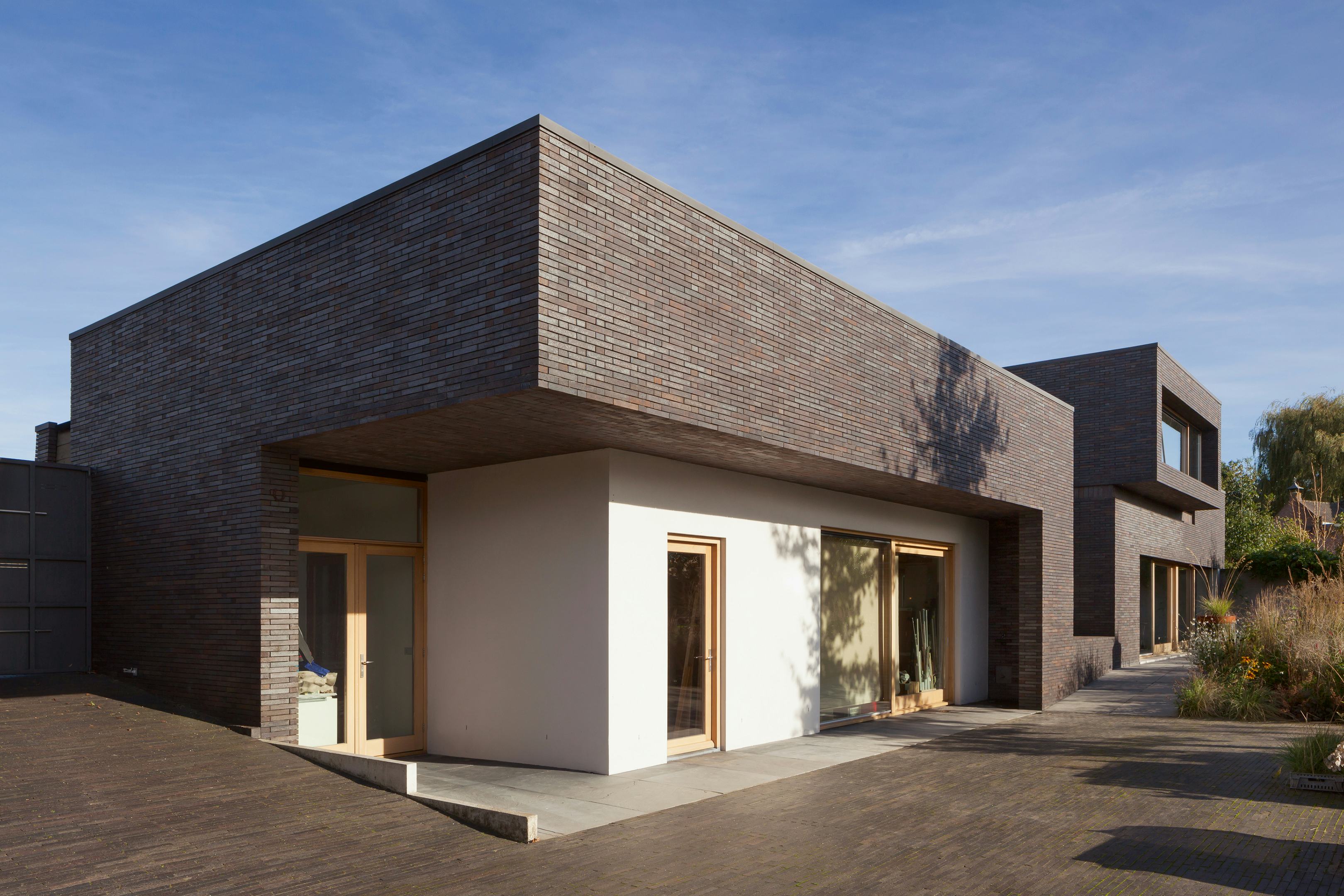 Een meanderende baksteenmuur vat alle volumes samen in een dynamisch geheel. - Beeld Daria Scagliola & Stijn Brakkee