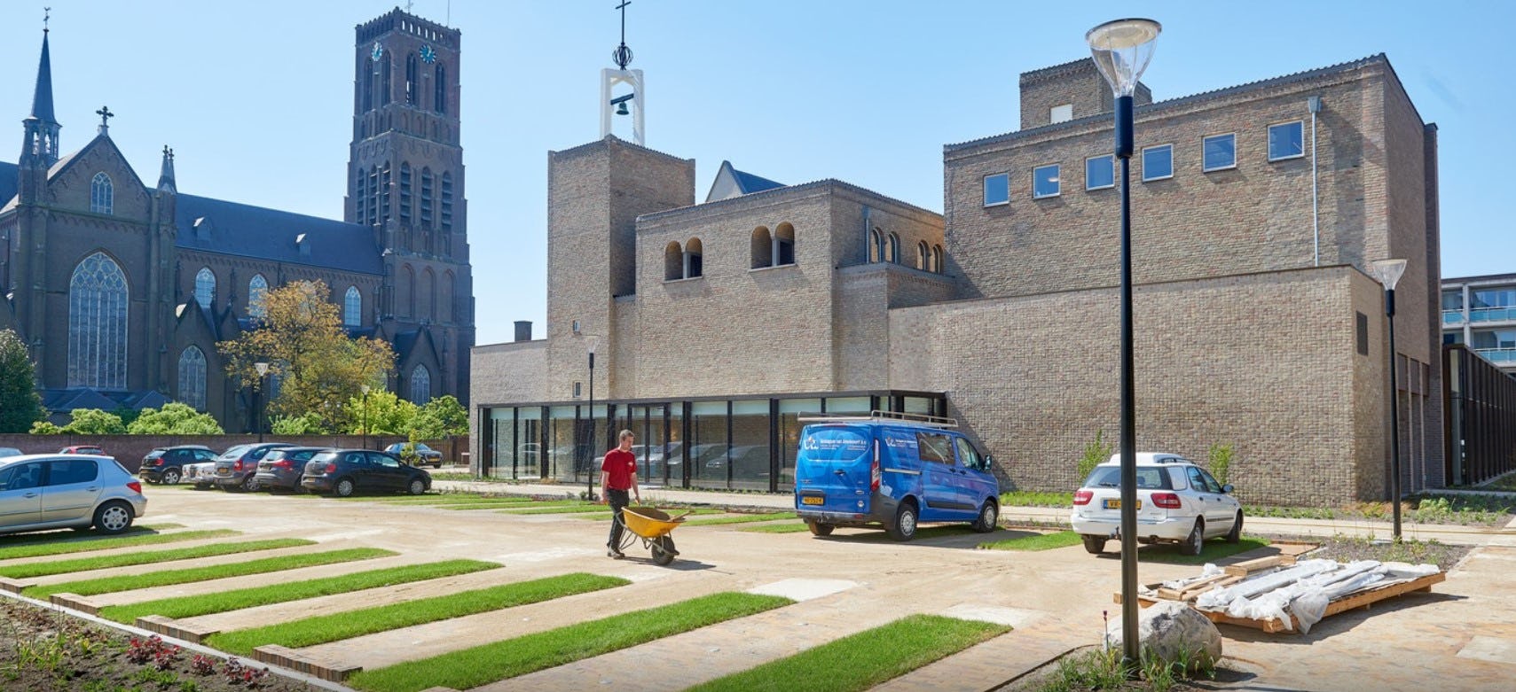 De gerenoveerde klokkentoren, kapel en trappenhuis met daarvoor de nieuwe uitbreiding in brons geanodiseerd aluminium en metselwerk in tegelverband