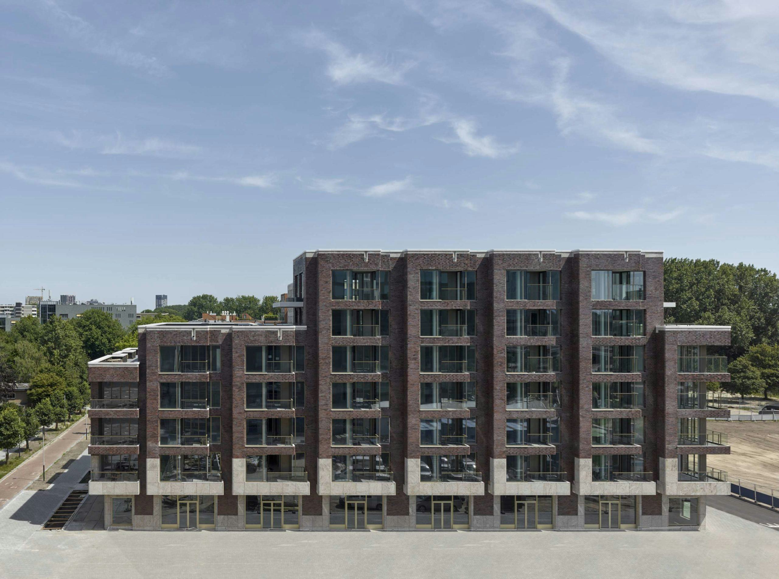 Woongebouw Sud in Amsterdam door Office Winhov is een stevig, stedelijk woongebouw dat opgevat is als een begrenzing van het plein. In de natuurstenen onderbouw zijn commerciële functies ondergebracht. Beeld Stefan Müller