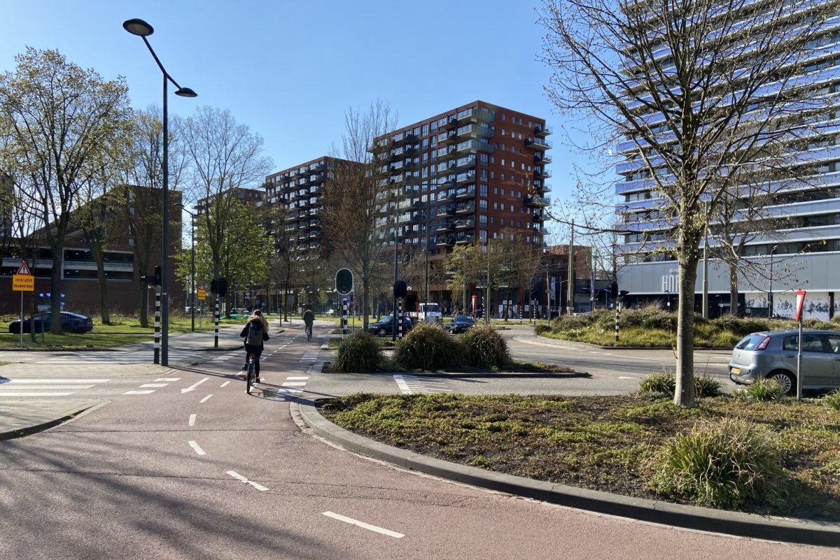 Boven op winkelcentrum In den Hoven in Delft zijn drie grote woongebouwen geplaatst, gezien vanaf Delflandplein in westelijke richting. Beeld Harm Tilman