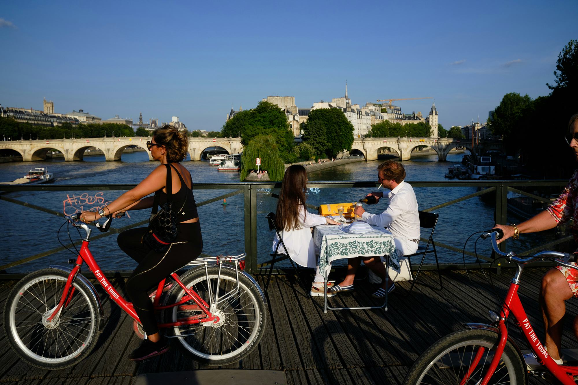 Tijdens de coronacrisis ontluikt een ware fietscultuur in Parijs – en een ruimtelijke competitie. De schilderachtige Pont des Arts over de Seine kijkt toe als tijdloos en stoïcijns icoon. Beeld Philippe Sarfati