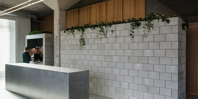 Balie en betonnen volumes door PUUR interieurarchitecten. Beeld Stijn Bollaert