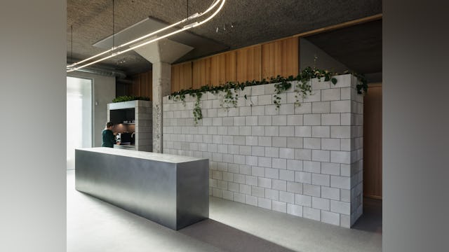 Balie en betonnen volumes door PUUR interieurarchitecten. Beeld Stijn Bollaert