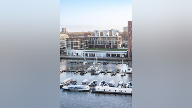 The Harbour Club kreeg een L-vormige nieuwbouw van zes lagen die de oude wijnterminal omarmt. Zo sluit het complex aan op de typologie van de nieuwbouw ernaast. Beeld Thijs van Stigt