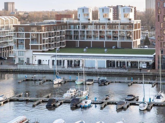The Harbour Club kreeg een L-vormige nieuwbouw van zes lagen die de oude wijnterminal omarmt. Zo sluit het complex aan op de typologie van de nieuwbouw ernaast. Beeld Thijs van Stigt
