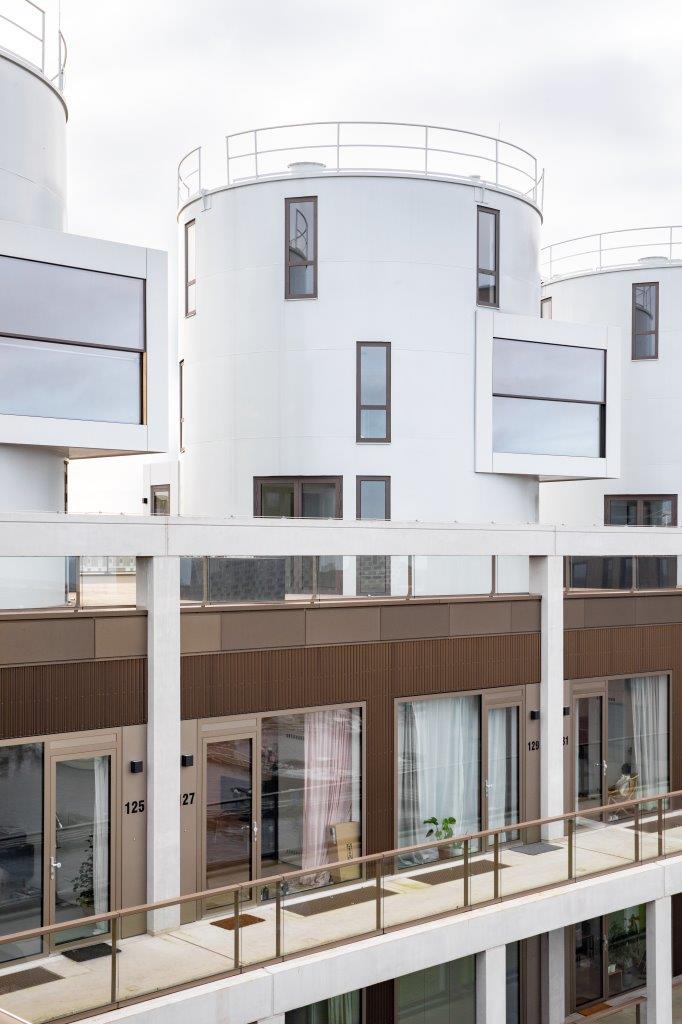 Boven op de starterswoningen zijn drie woningen in oude wijnsilo’s neergezet. Beeld Thijs van Stigt