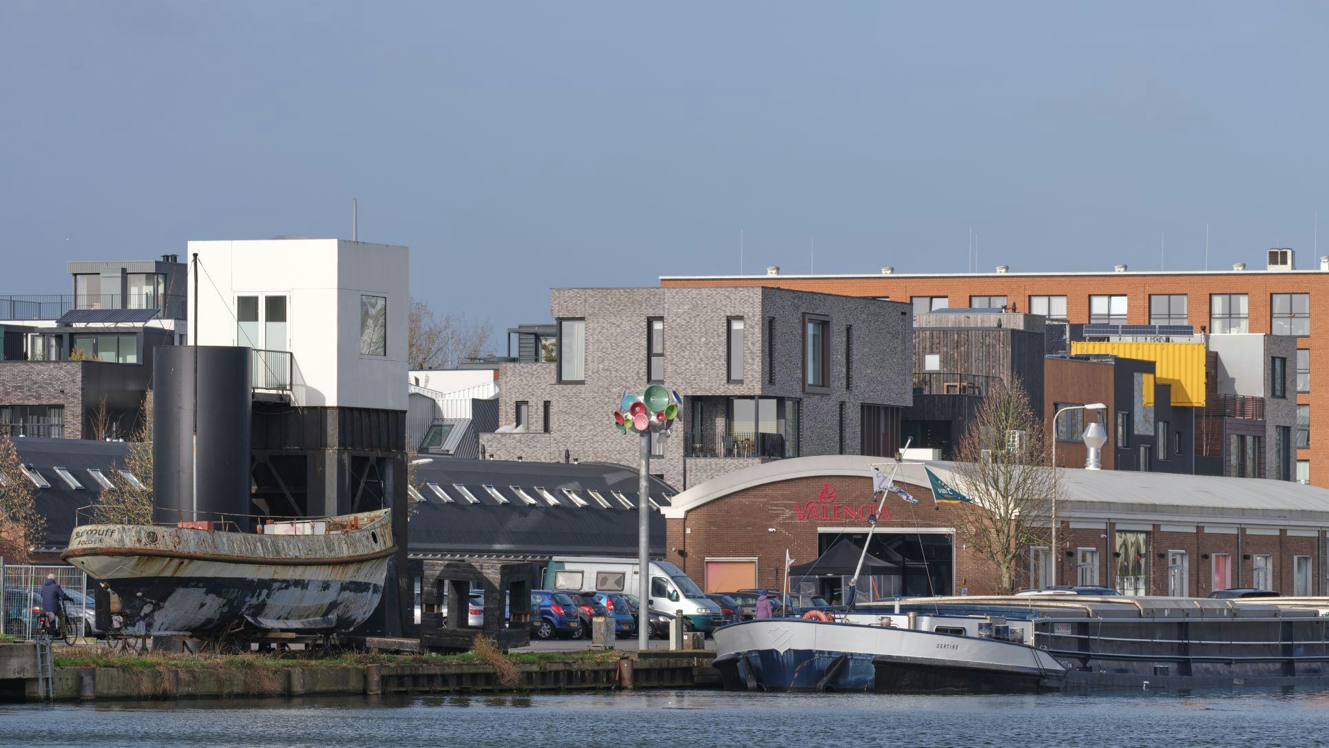 Een binnenvaartschip aan de kade van de Eerste Havenarm. Woonfuncties en industrie ontmoeten elkaar in Het Havenkwartier. Beeld Jeroen Musch