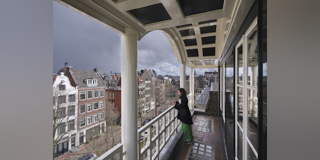 Architect Ruby van den Munckhof in de loggia van een kantoorpand aan de Keizersgracht 105-107 hoek Blauwburgwal in Amsterdam. Beeld Jeroen Musch