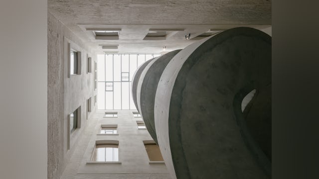 Eén van de meest opvallende nieuwe elementen is de monumentale, vrijdragende wenteltrap in ter plaatse gestort zichtbeton. Beeld Stijn Bollaert