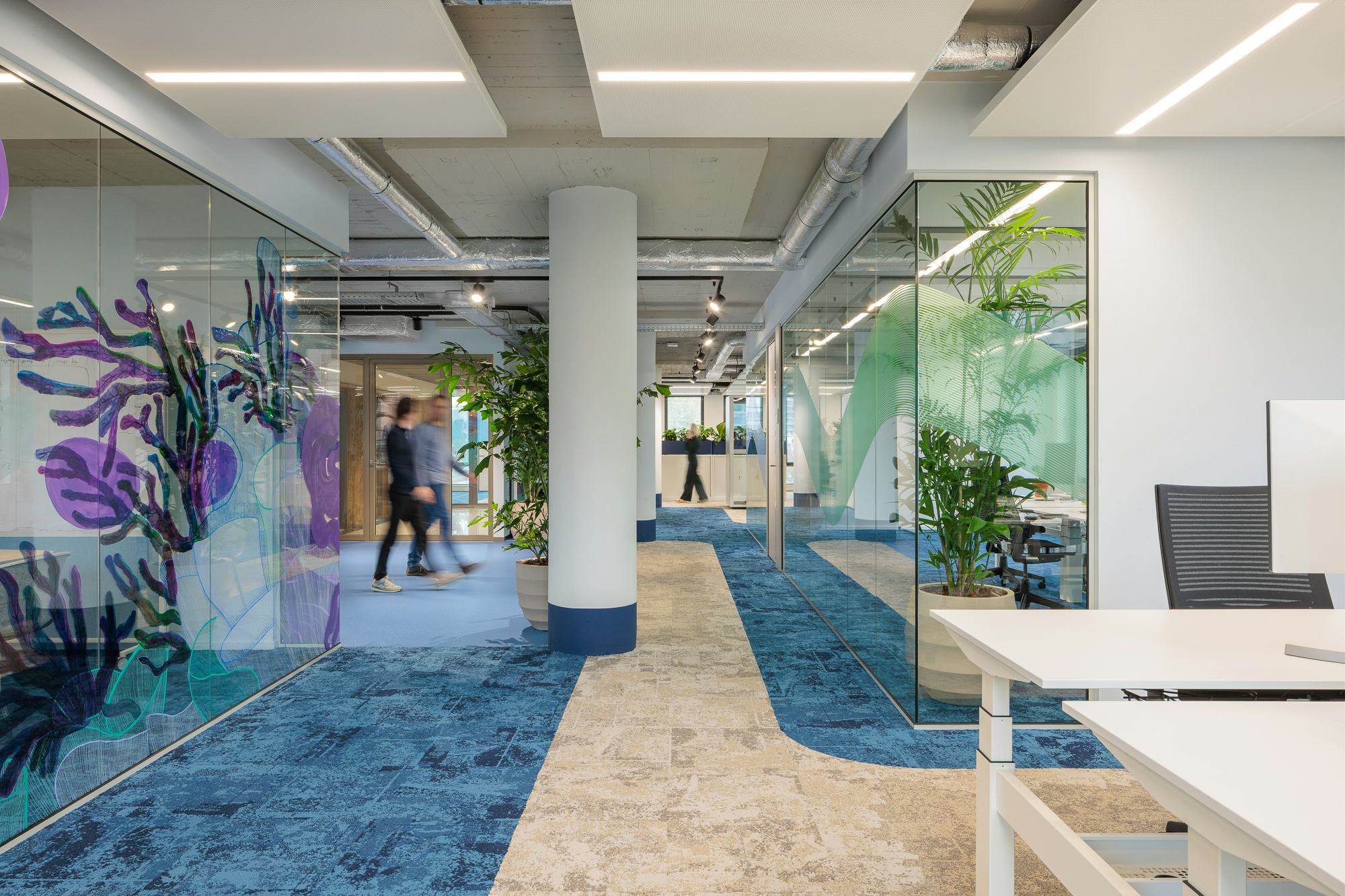 Open werkruimten bevinden zich tussen gesloten ruimten voor samenwerking en overleg.